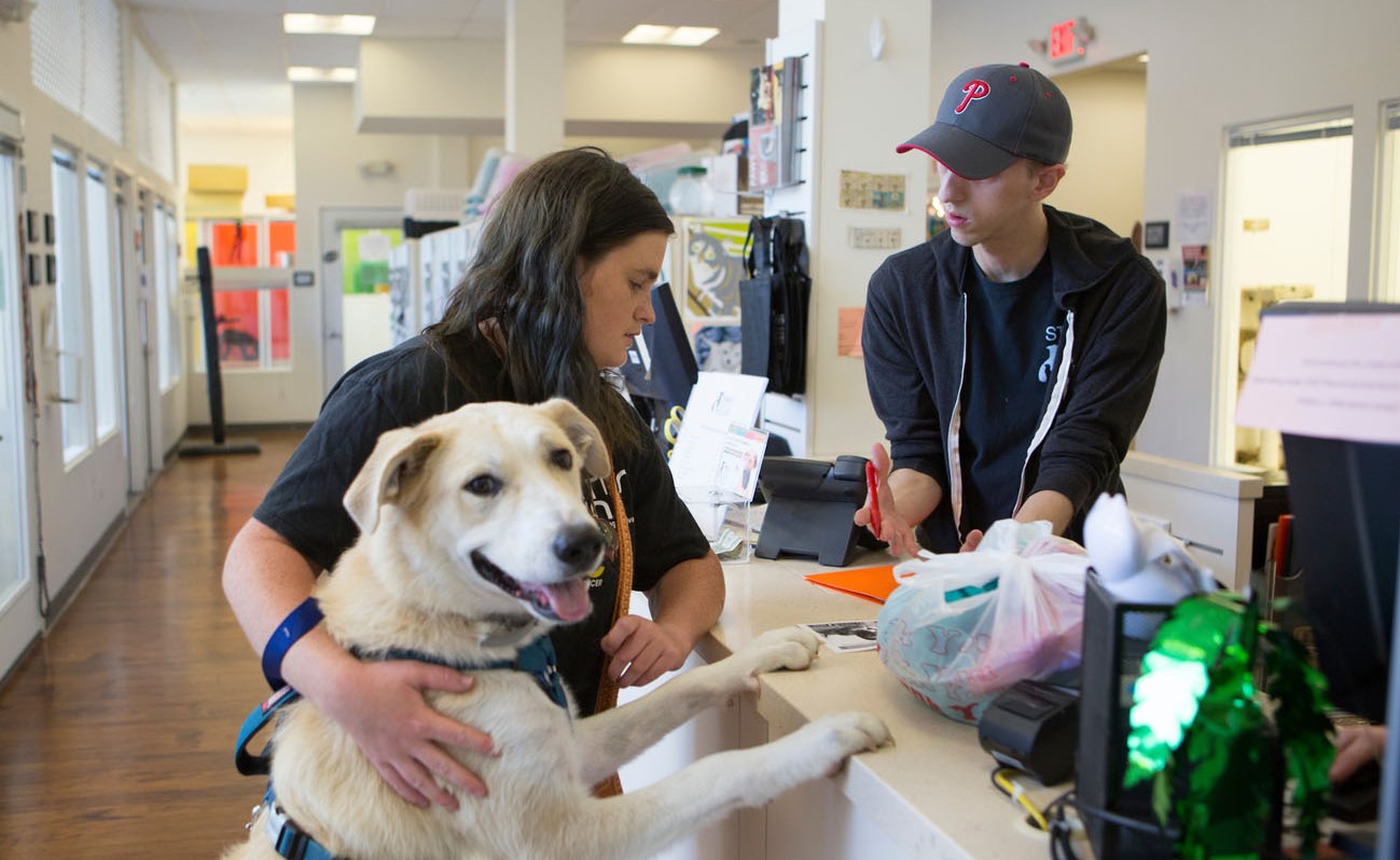 a woman with his dog at a rescue counter